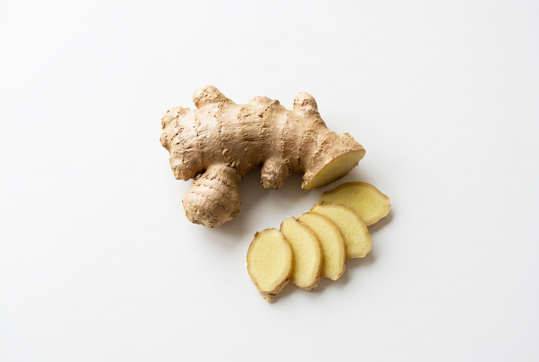 Fresh ginger root on a white surface